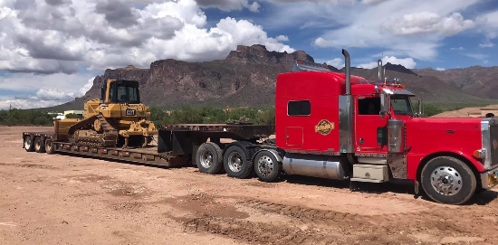 semi with flatbed trailer hauling a bulldozer | Storbakken & Sons